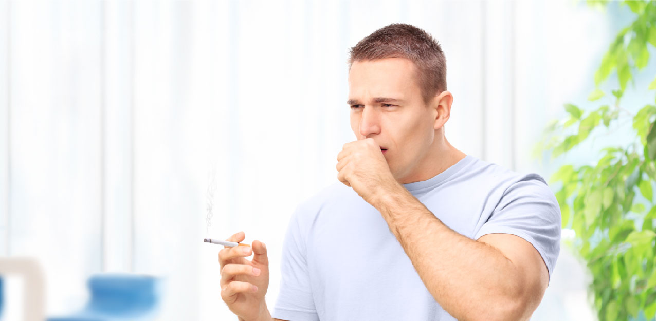 A man holding his cigarette and cough at the same time